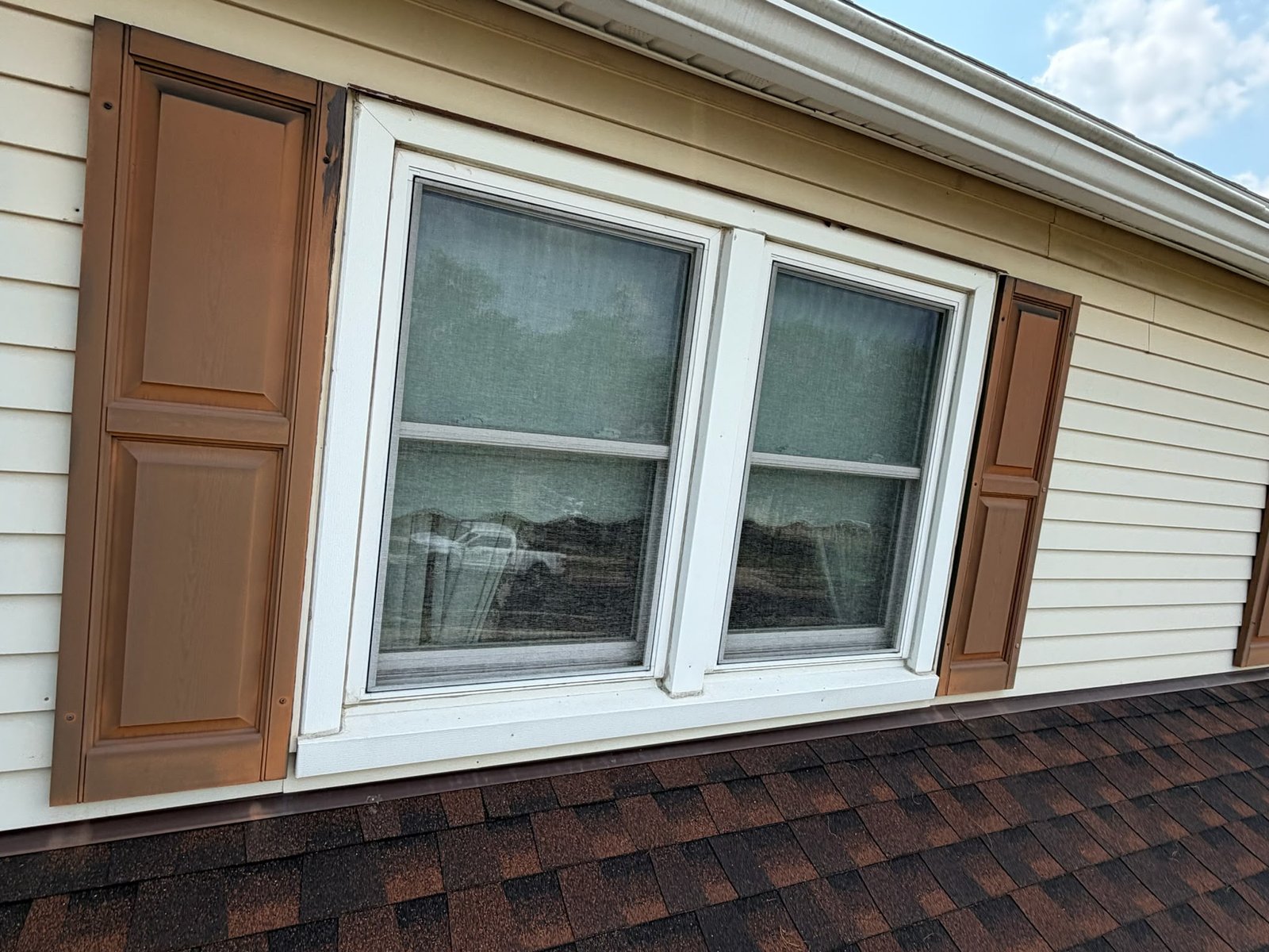 Weathered brown shutters showing years of sun and wear before restoration