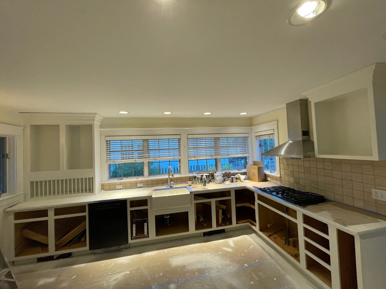 Kitchen mid-renovation with cabinet doors removed for a factory-style repaint