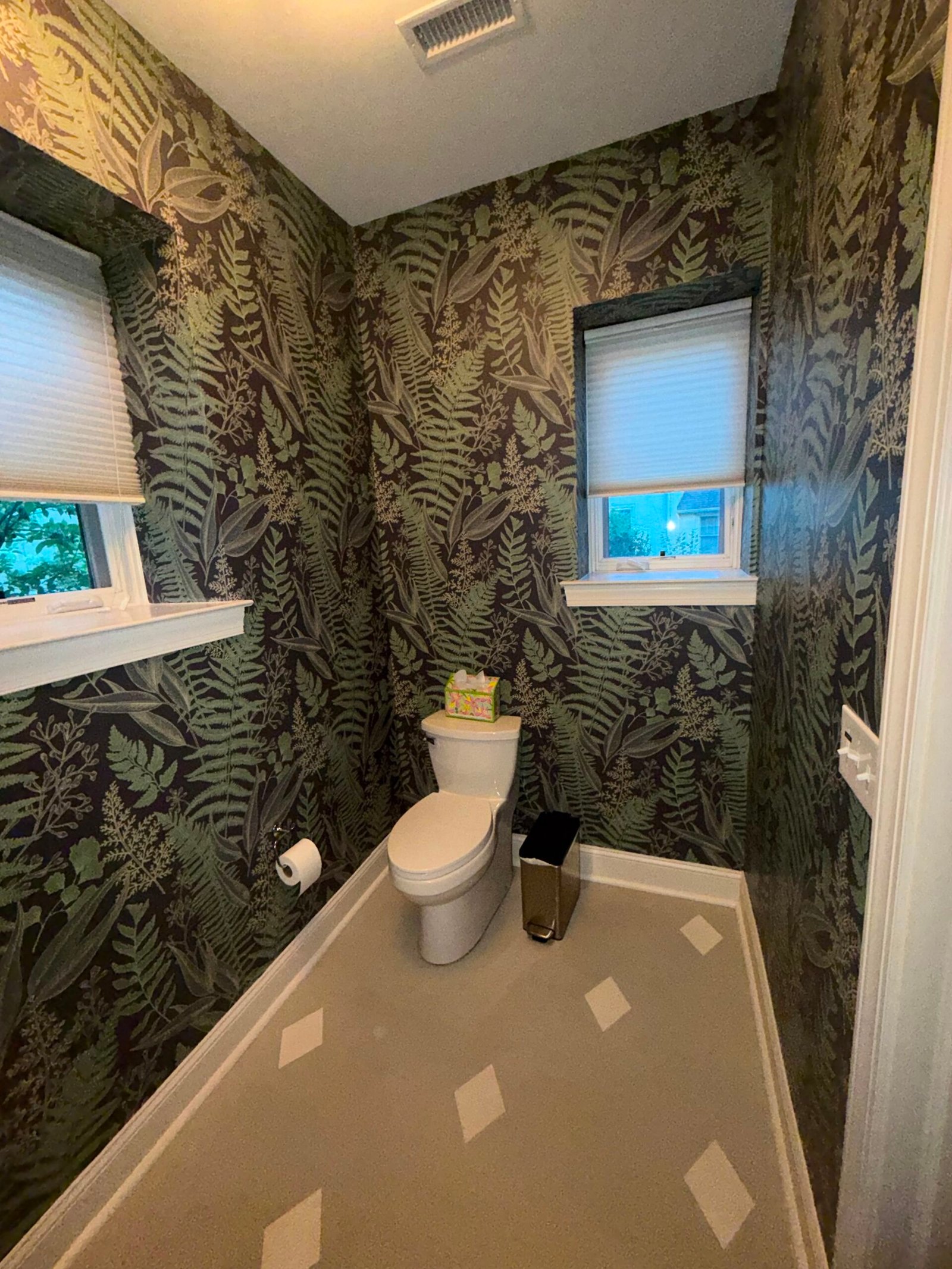 Powder room wrapped in a dark botanical fern wallpaper after installation